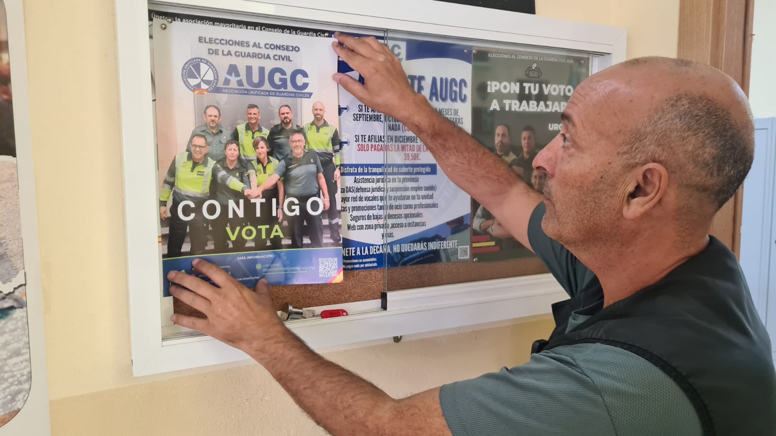 Rachid, secretario de AUGC en Ceuta pegando un cartel en un tablón.