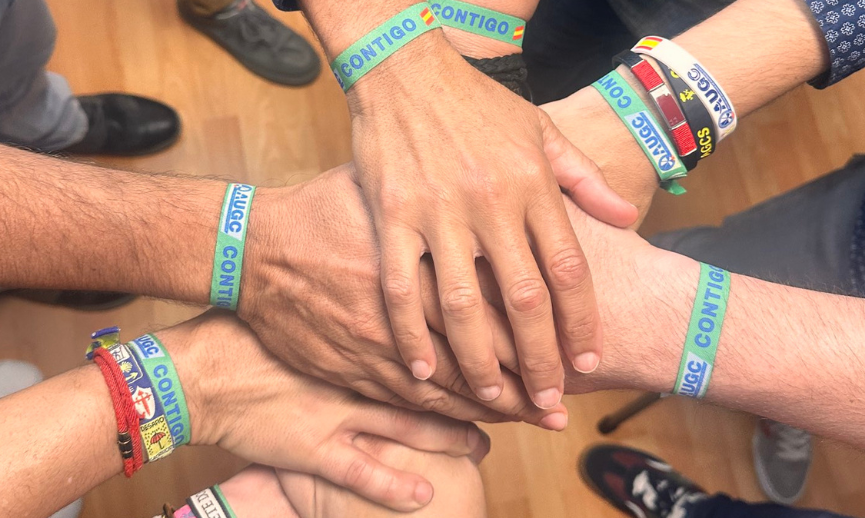 Manos unidas con pulseras de AUGC. Simpatizantes.