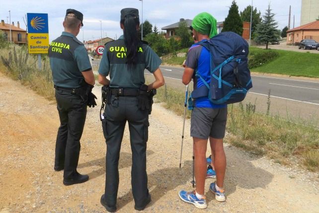Dos guardias civiles atienden a un peregrino en el Camino de Santiago.