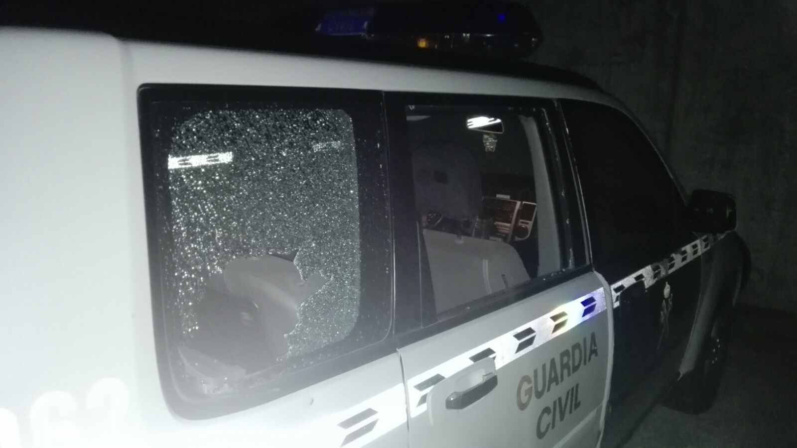 Estado del vehículo oficial tras haber sufrido la agresión.