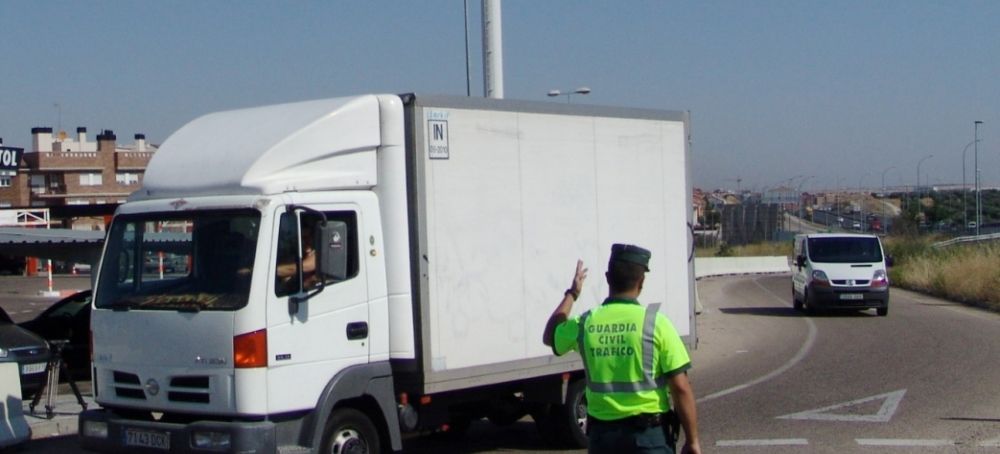 Un guardia civil regula el tráfico de un camión.