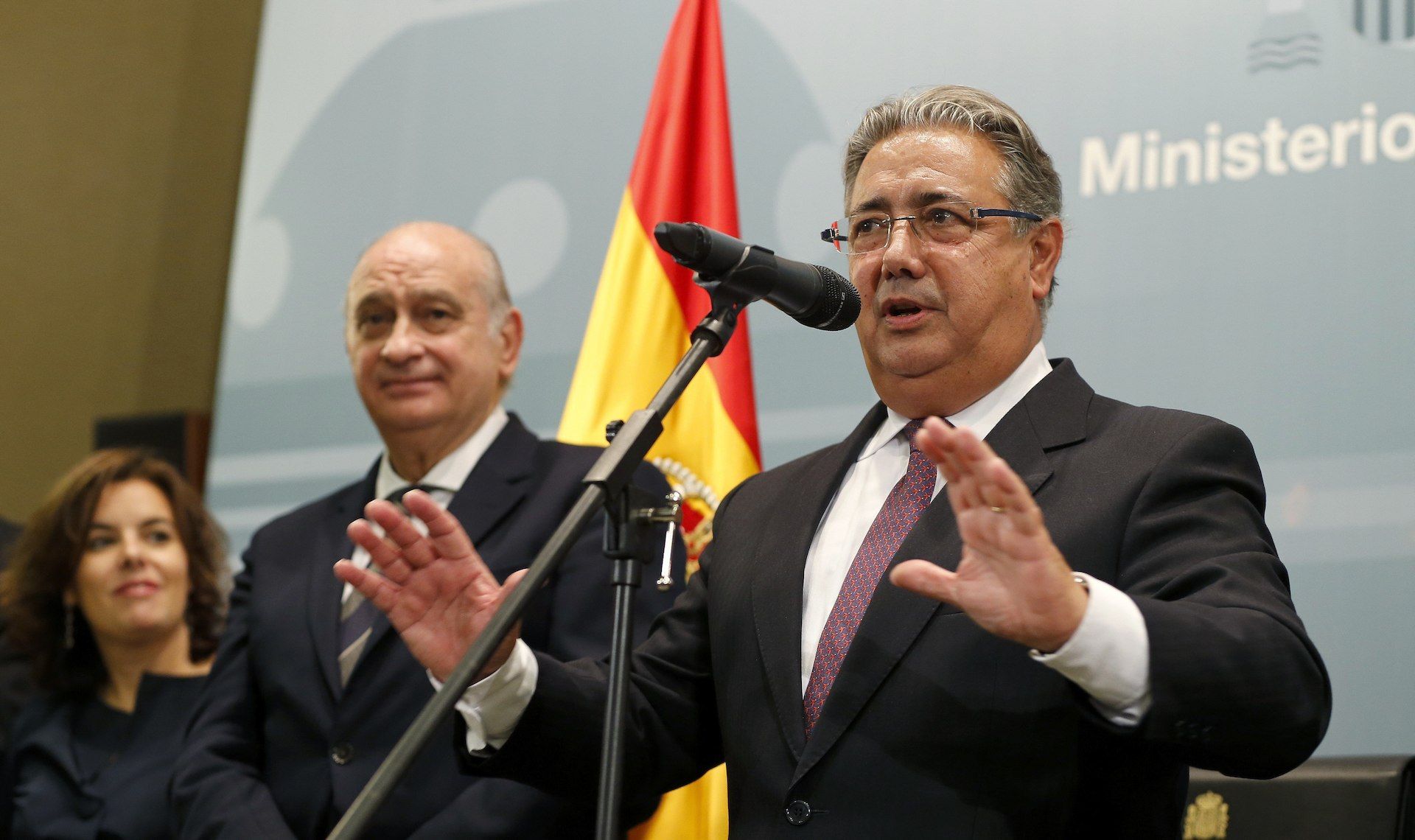 El ministro del Interior, Juan Ignacio Zoido, con su predecesor en el cargo, Jorge Fernández Díaz, ambos contemplados por una satisfecha Soraya Sáenz de Santamaría.