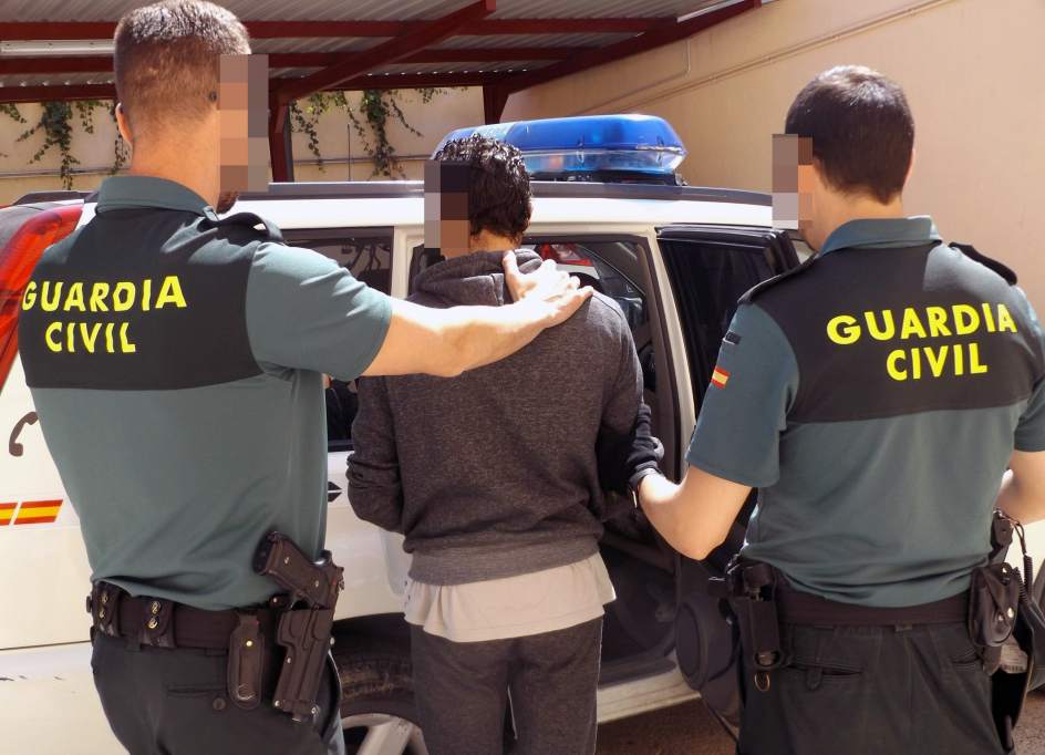 Dos guardias civiles conducen a un detenido.