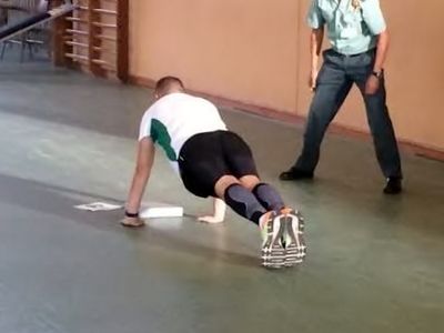 Un agente realiza flexiones ante un evaluador.