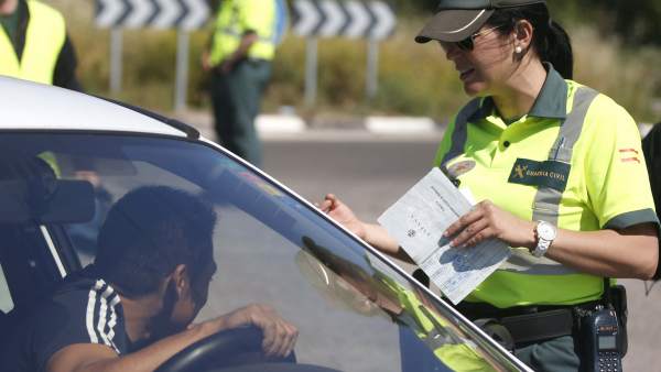 Una guardia civil de Tráfico solicita su documentación a un conductor.
