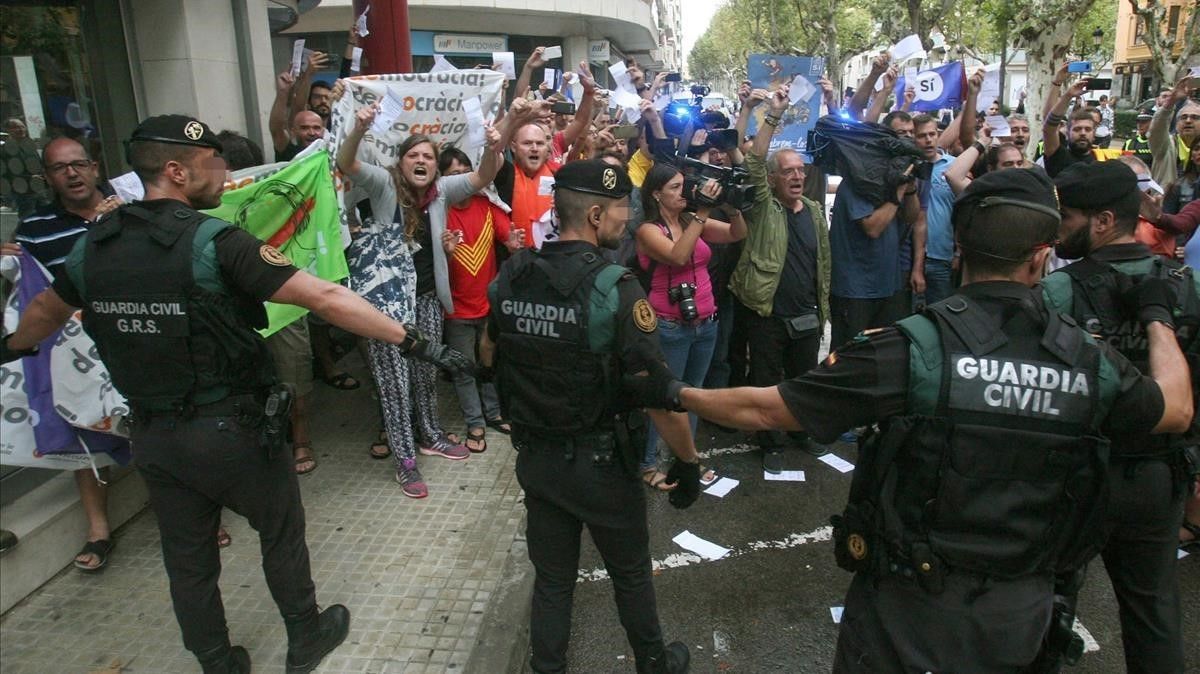 Guardias civiles ante manifestantes independentistas.