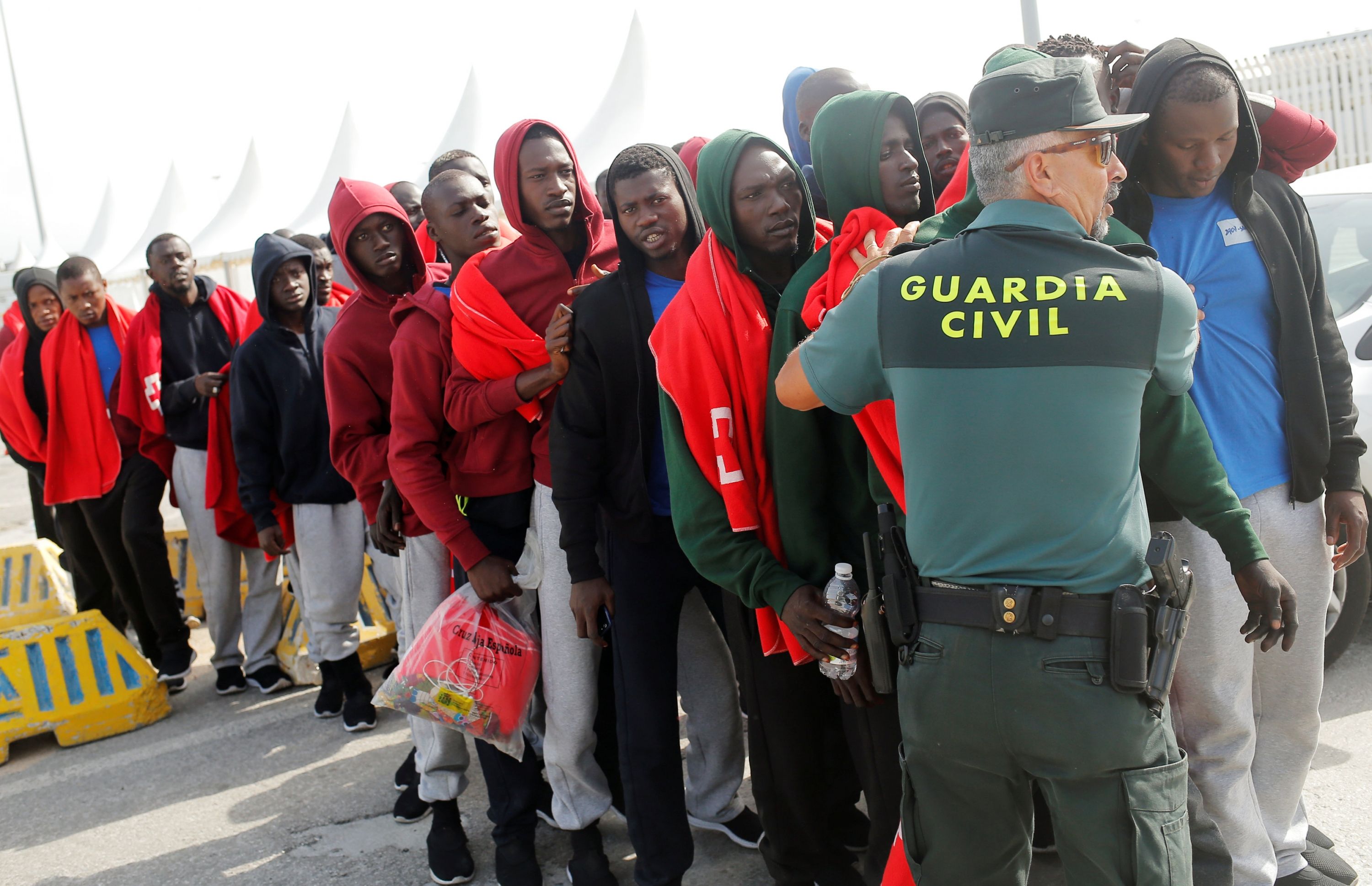 Un guardia civil con inmigrantes. Inmigración irregular.