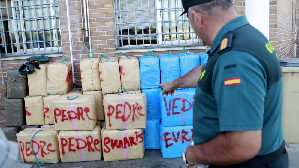 Un guardia civil señala fardos de droga incautados en Campo de Gibraltar. Foto: EFE
