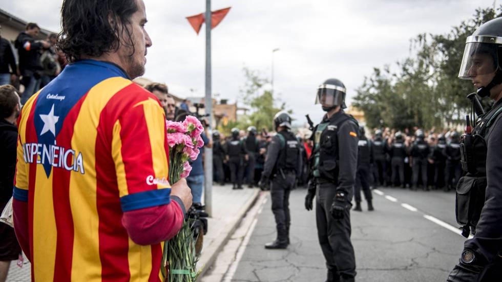 Un manifestante independentista ante guardias civiles.