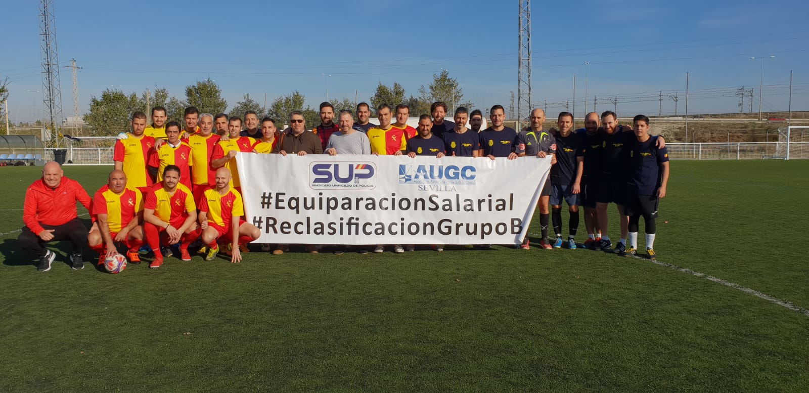 Los dos equipos posan con una pancarta en la que expresan las reivindicaciones de guardias civiles y policías nacionales.