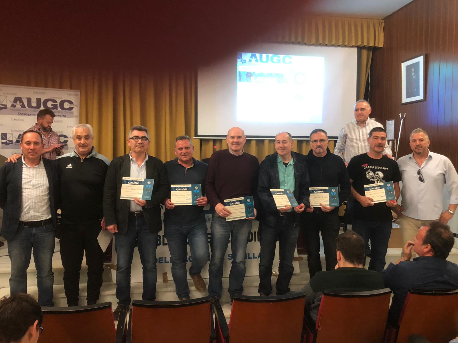 Los compañeros homenajeados posan con sus diplomas de reconocimiento.