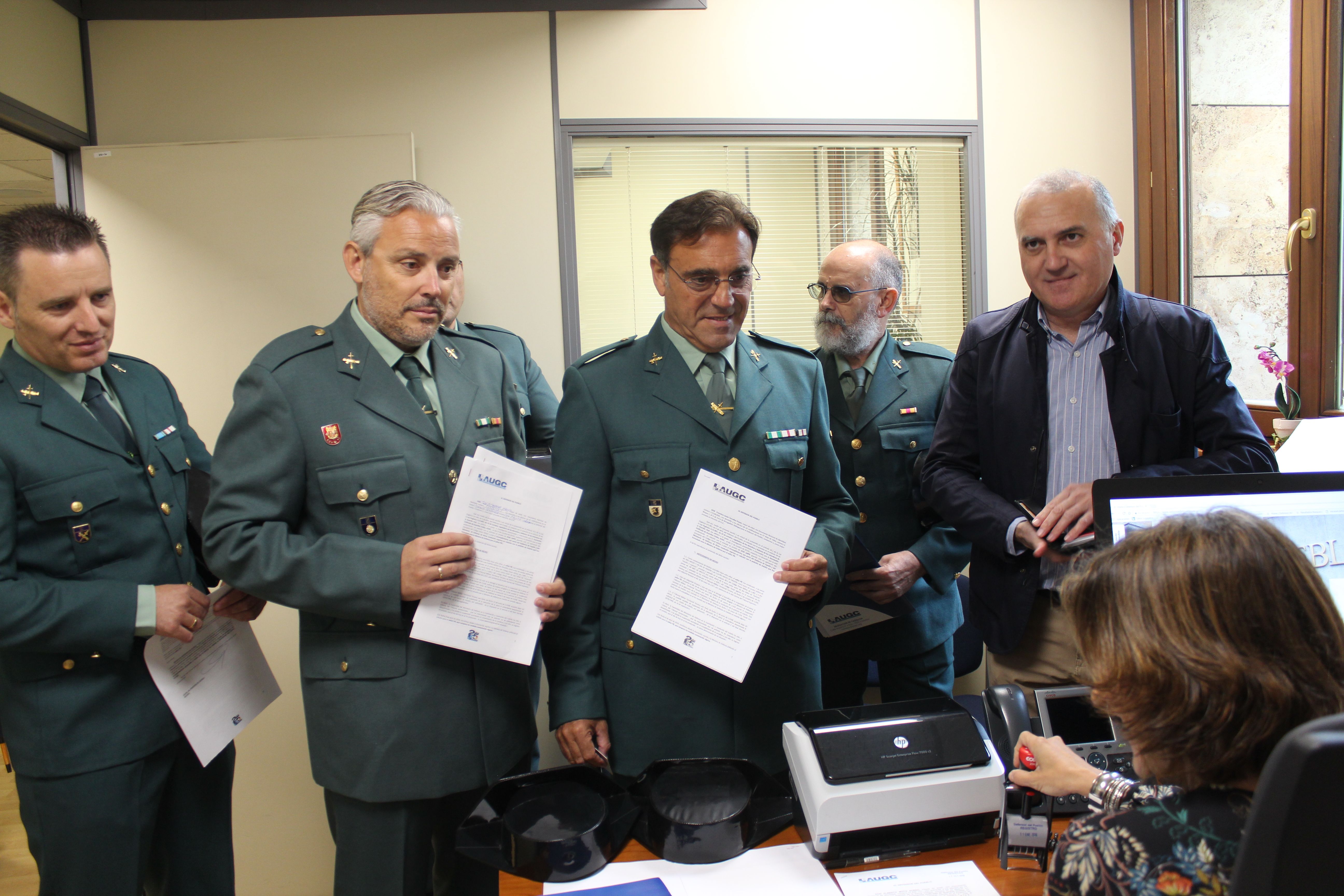Momento en el que el secretario general de AUGC, Alberto Moya, y varios compañeros retirados hacen entrega de sus respectivos escritos ante el registro del Defensor del pueblo.