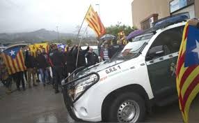 Un vehículo de la Guardia Civil ante un grupo de independentistas.