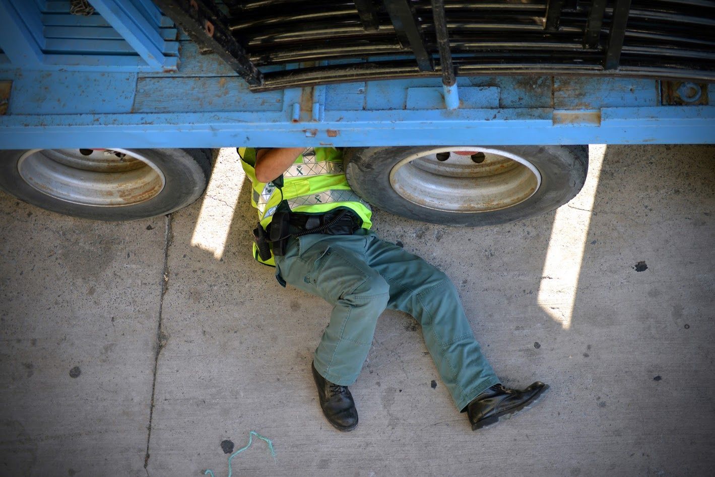 Un guardia civil examina los bajos de un vehículo.