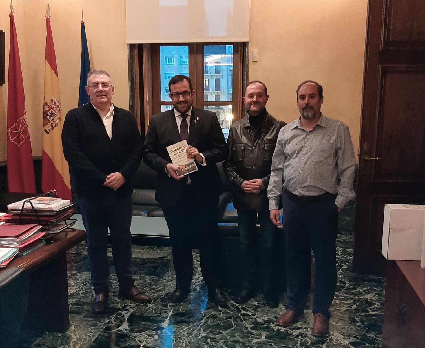 El vicepresidente del Gobierno de Navarra, Javier Remírez, posa con el libro Guardias Civiles, ciudadanos de uniforme en busca de derechos, acompañado por los representantes de AUGC.