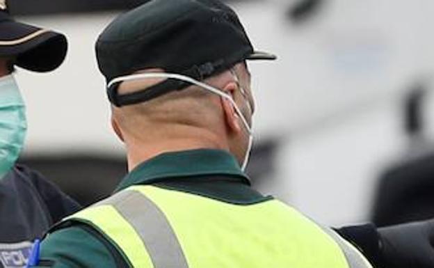 Un guardia civil se protege con una mascarilla