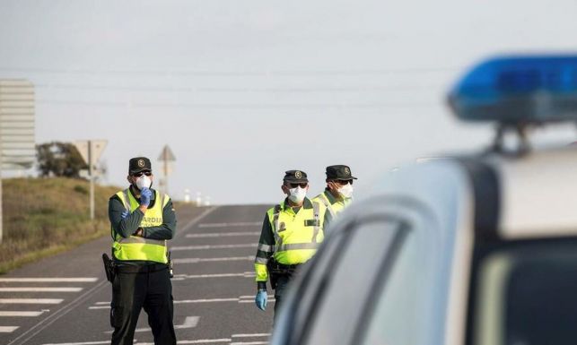 Un grupo de guardias civiles se protegen con mascarillas durante un control de carretera.