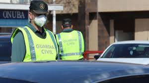 Un guardia civil se protege con una mascarilla durante un control de tráfico.