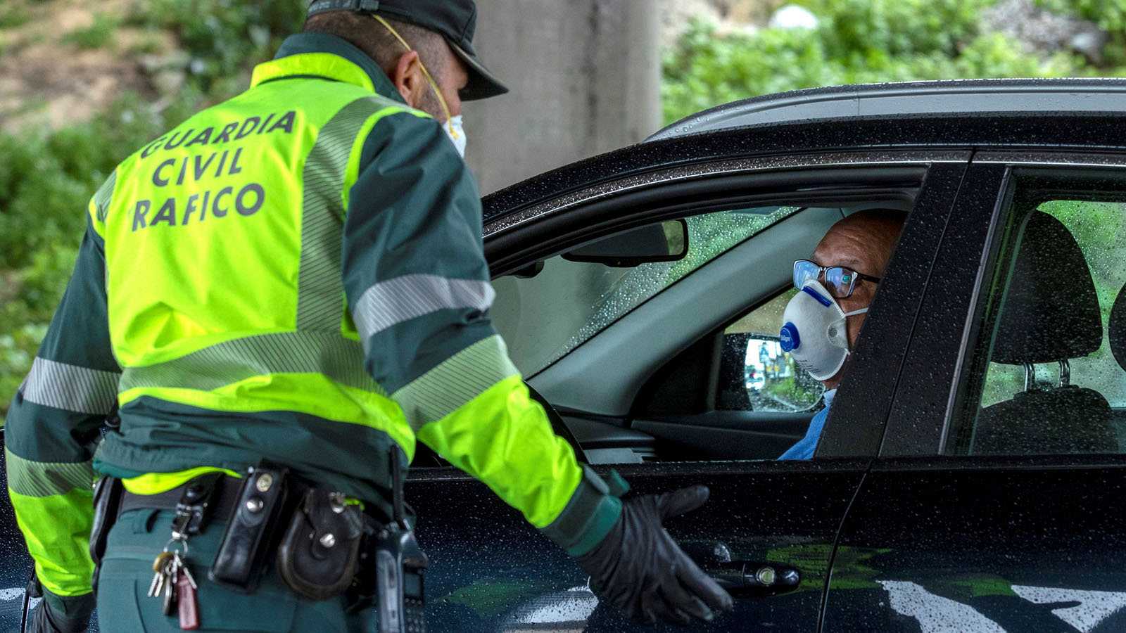 Un guardia civil, con un conductor durante un control de tráfico por motivo del coronavirus.