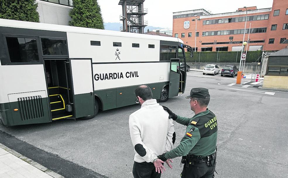 Un guardia civil conduce a un preso durante un traslado.