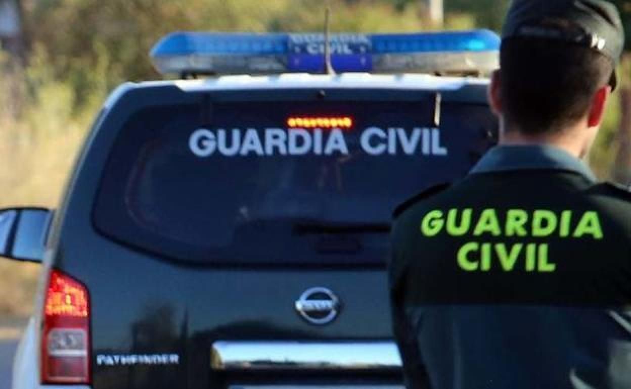 Un guardia civil, junto a su vehículo oficial.