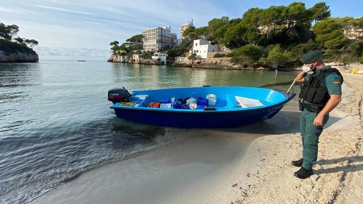 Un guardia Civil, junto a una patera en Mallorca.