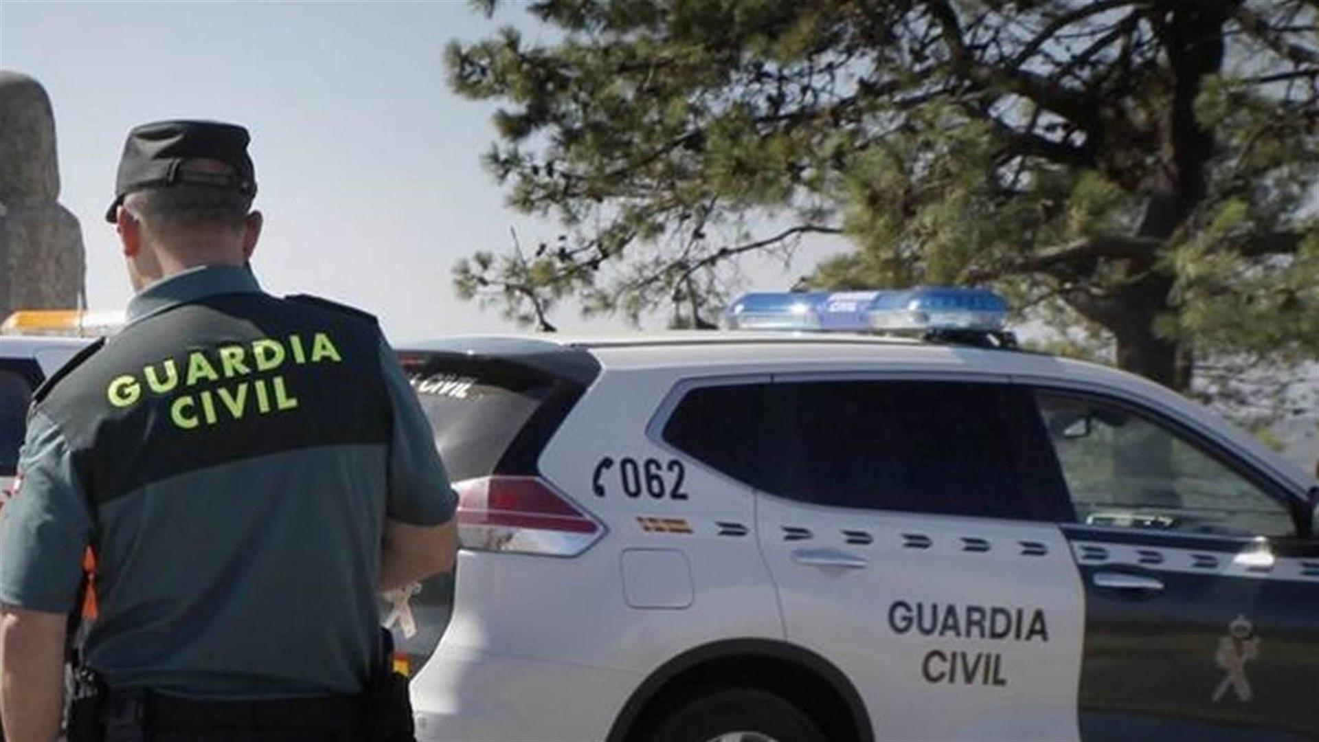 Guardia civil junto a su vehículo oficial.