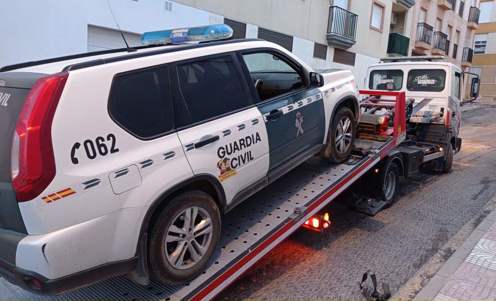 Una grúa recoge un vehículo averiado de la Guardia Civil.