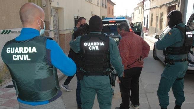 Guardias civiles conducen a los detenidos por el asalto y robo en el puesto toledano de Villafranca de los Caballeros.