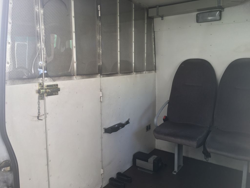  Asientos para agentes de custodia, perpendiculares al sentido de la marcha.