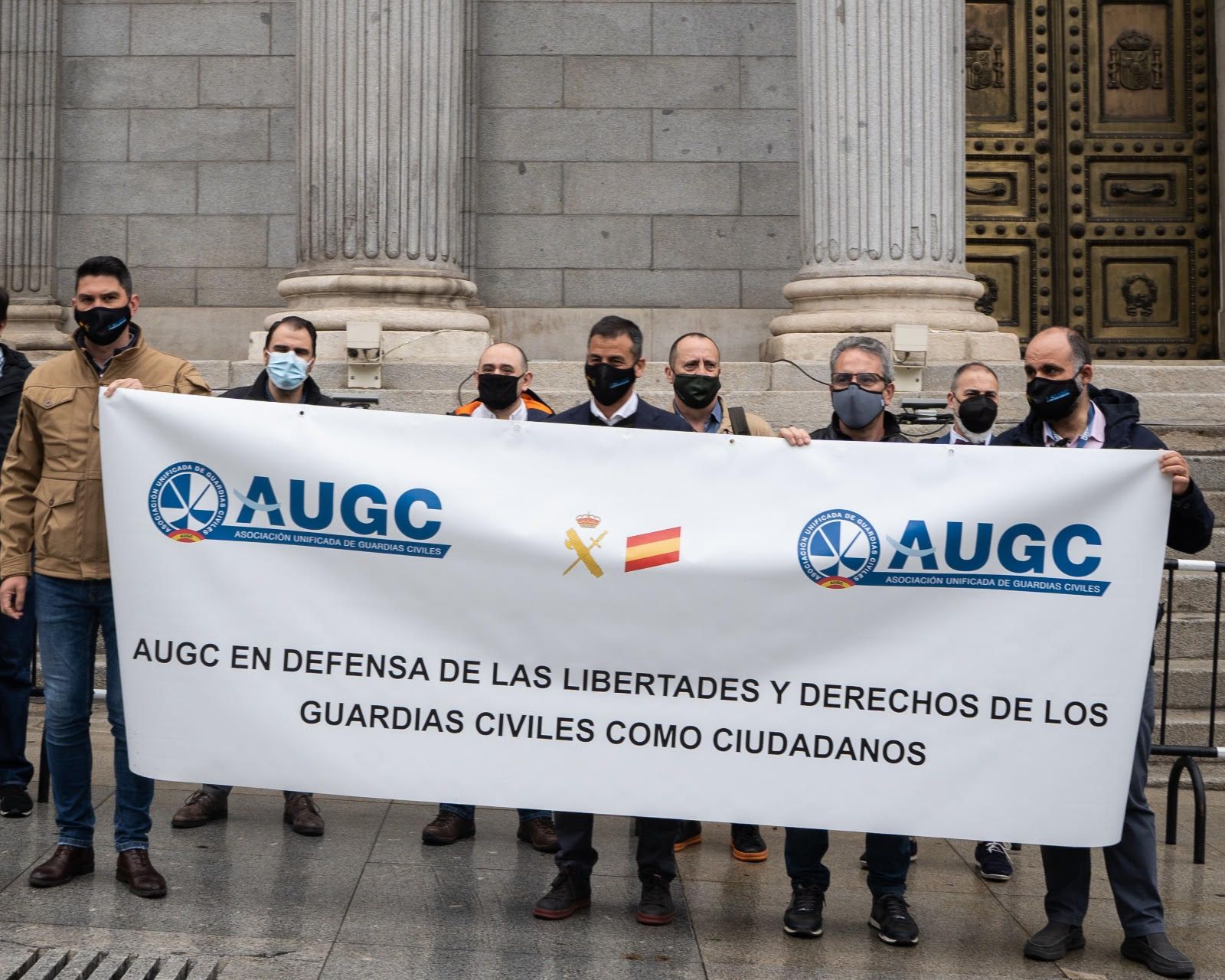 Los representantes de AUGC ante la pancarta reivindicativa