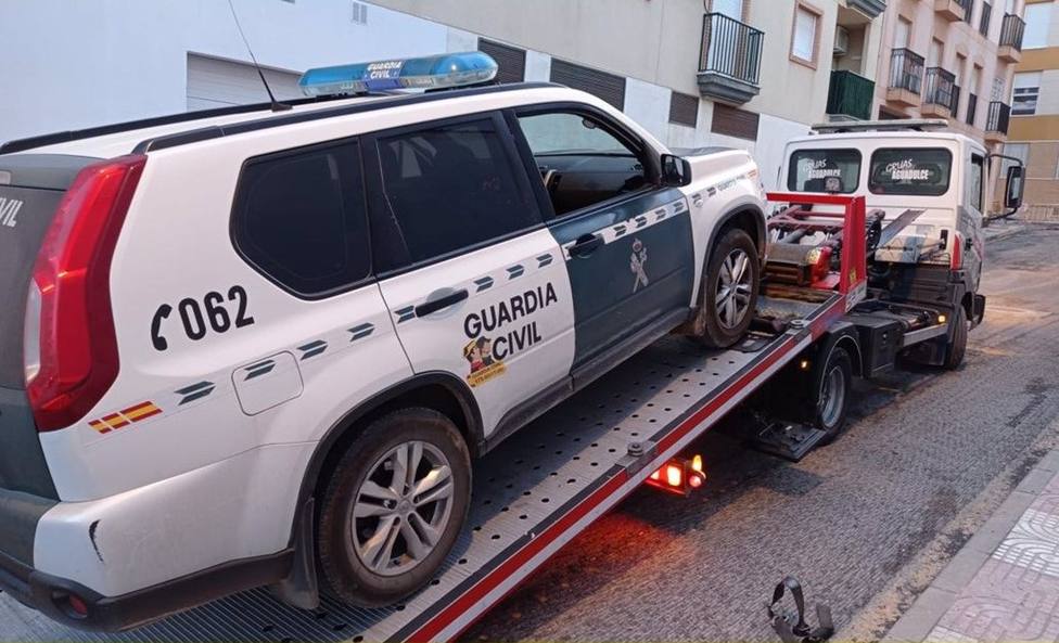 Una grúa se ocupa de un vehículo de la Guardia Civil averiado.