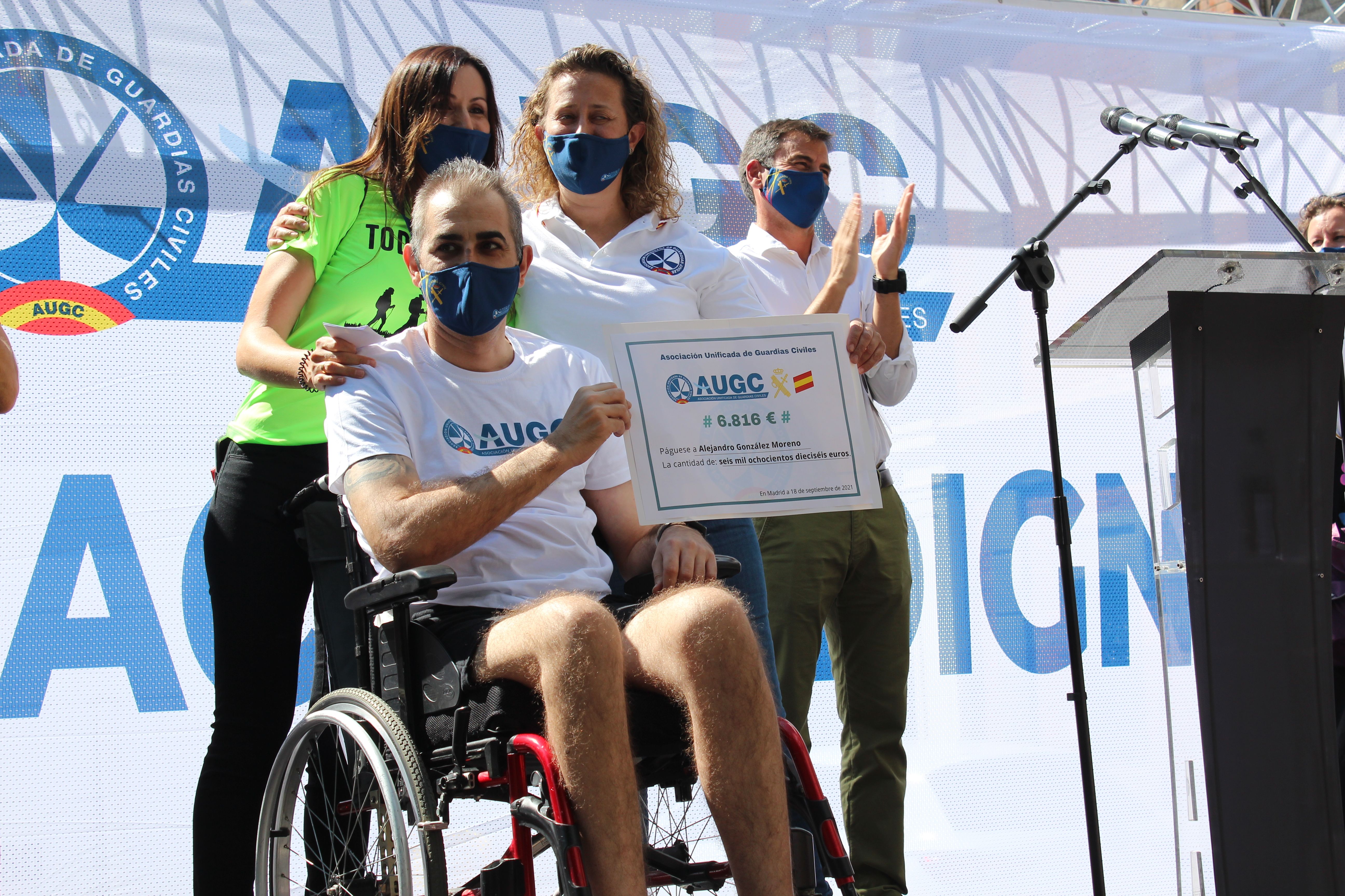 Alejandro, acompañado por su esposa Montse, recibe el cheque solidiario de AUGC de manos de Eva María Gómez, secretaria general de la delegación de Madrid.