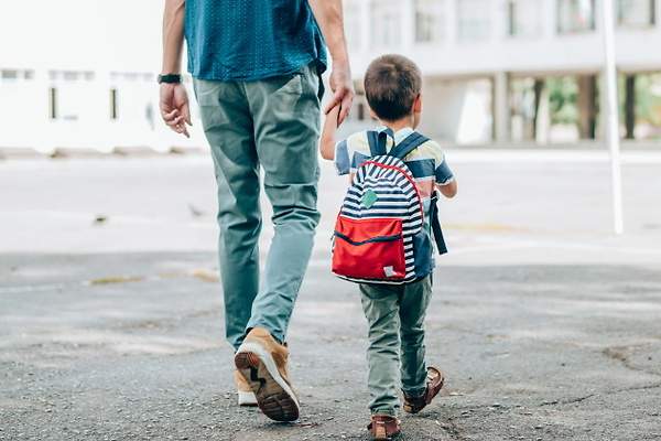 Un padre lleva a su hijo al colegio.