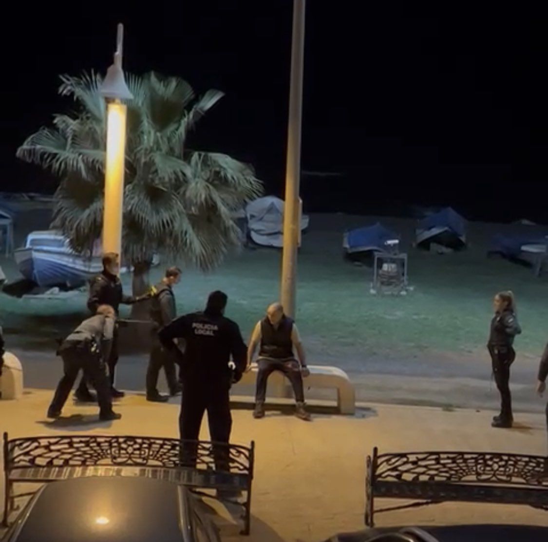 El atacante, ya reducido, sentado en unos bancos del paseo marítimo de Nuestra Señora del Carmen (Málaga).