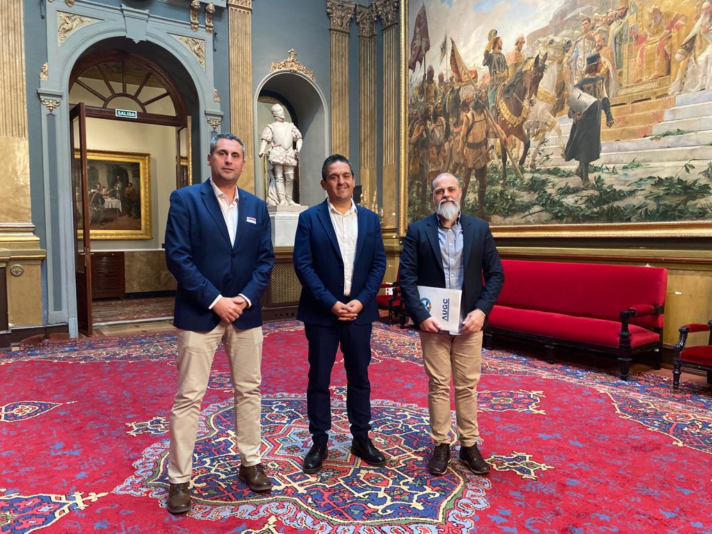 Rafael Sánchez, de la Comisión de los Servicios de Protección y Seguridad de AUGC, y Gustavo Adolfo, de la Secretaría Nacional de Relaciones Institucionales, con el senador Carles Mulet antes de la reunión.